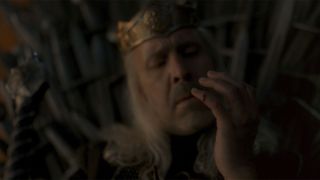 King Viserys staring at his bloody finger after cutting himself on the Throne.