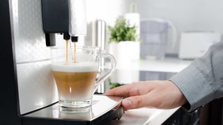 A coffee being brewed using a bean-to-cup coffee maker in a modern kitchen