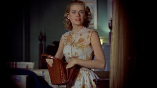 Grace Kelly stands alone in an apartment in Rear Window
