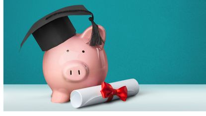 Apiggybank wearing a graduation cap sits on a table next to a rolled-up diploma