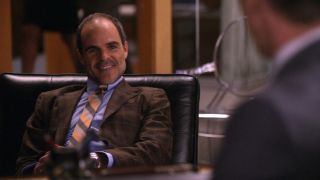 Michael Kelly biting his lip while sitting in a chair on The Good Wife.