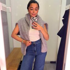 Senior Shopping Editor Marina wearing a pair of Frame jeans, a white top and a grey caridgan on her shoulders.