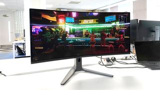 Alienware 34 AW3423DWF monitor on white desk with Cyberpunk 2077 gameplay on screen