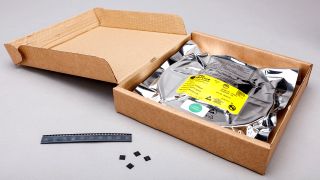 A reel of RP2040 chips in a box, with loose chips on the side