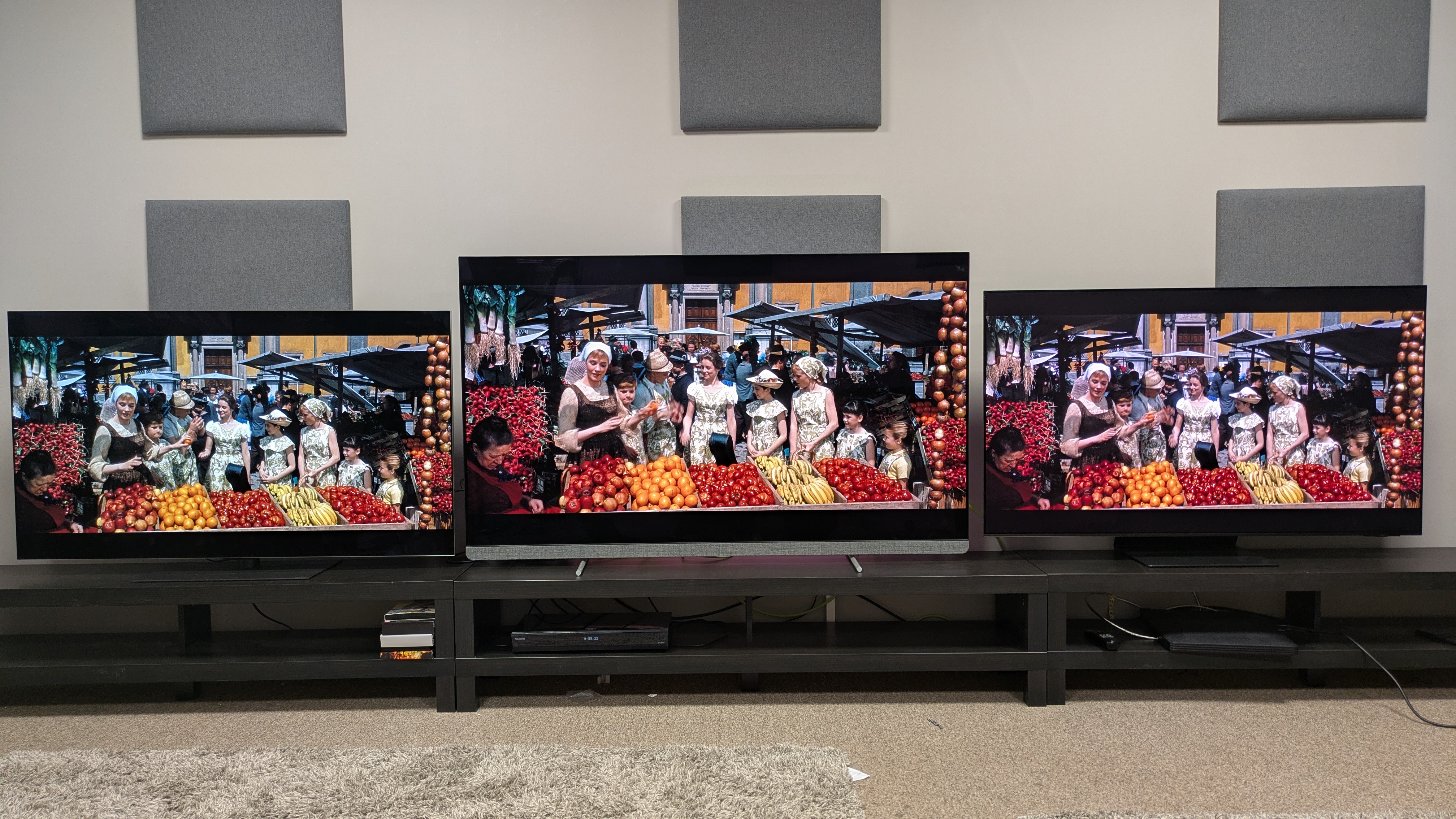 LG G5 (left) vs Philips OLED910 (middle) vs Samsung S95F (right) showing Maria and Von Trapp children at a market from The Sound of Music on screen