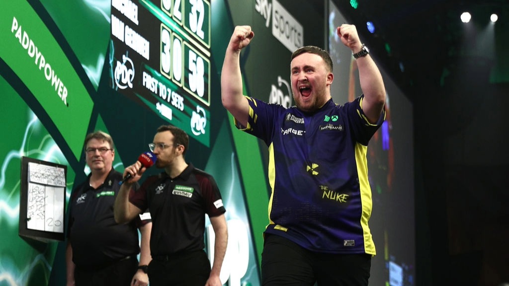 Luke Littler raises his hands to the air in celebration at winning the 2025 PDC World Darts Championship.