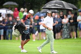 Rory McIlroy walks with an umbrella