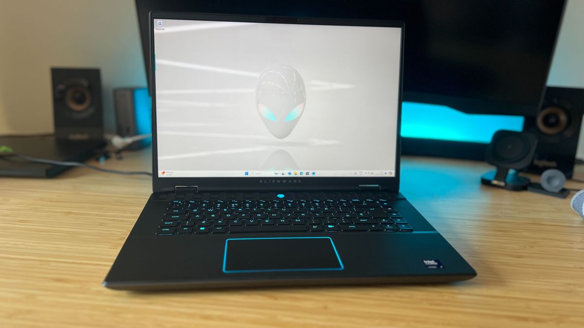 Alienware M16 R2 gaming laptop open on home screen on a gaming desk with blue lighting