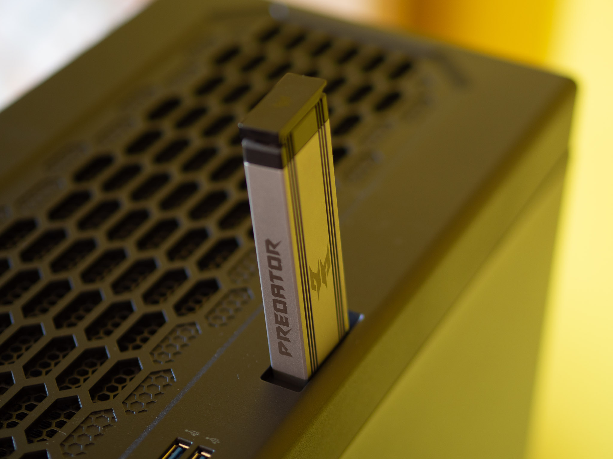 Acer Predator Orion 7000 gaming desktop PC on a wooden desk and yellow background