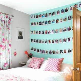 kids bedroom with personal photos on blue wall white bed and photoframe on wall
