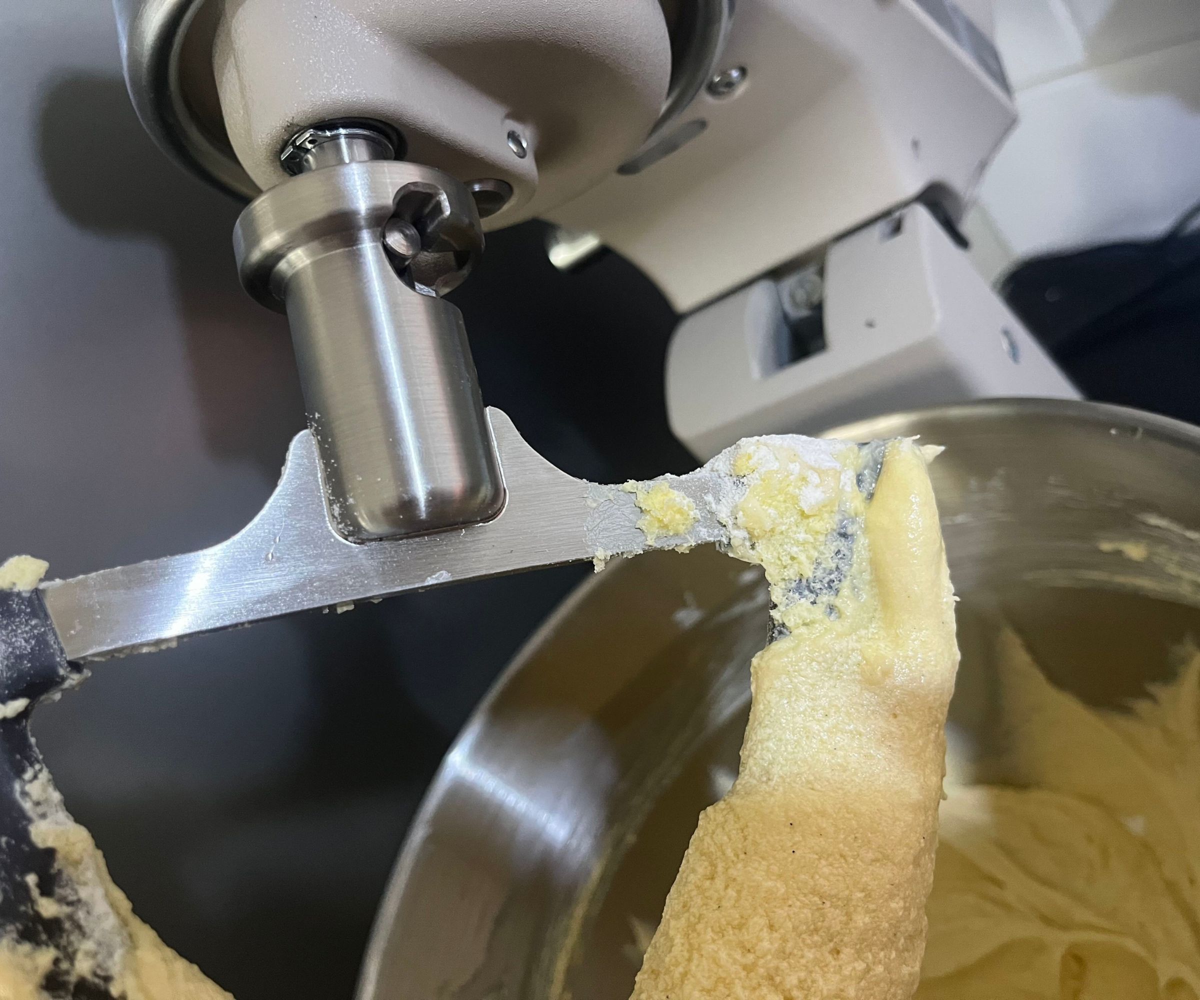 A close up of some flour stuck to the top of the Flex Edge paddle for the KitchenAid Artisan Plus Stand Mixer