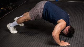 Man performs pike press-up