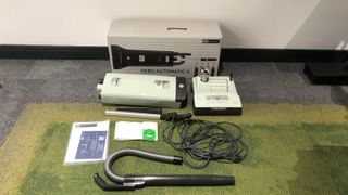 the SEBO vacuum, in green, unboxed with all the relevant parts around it