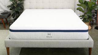The Helix Midnight Mattress placed on a silver fabric bed frame