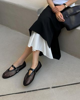 Woman wearing Alaia ballerinas.