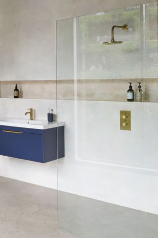 How to choose a shower: a Britton Hoxton shower in a pale wet room with dark blue vanity unit.