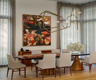 dining room with white chairs and bold artwork contemporary chandelier