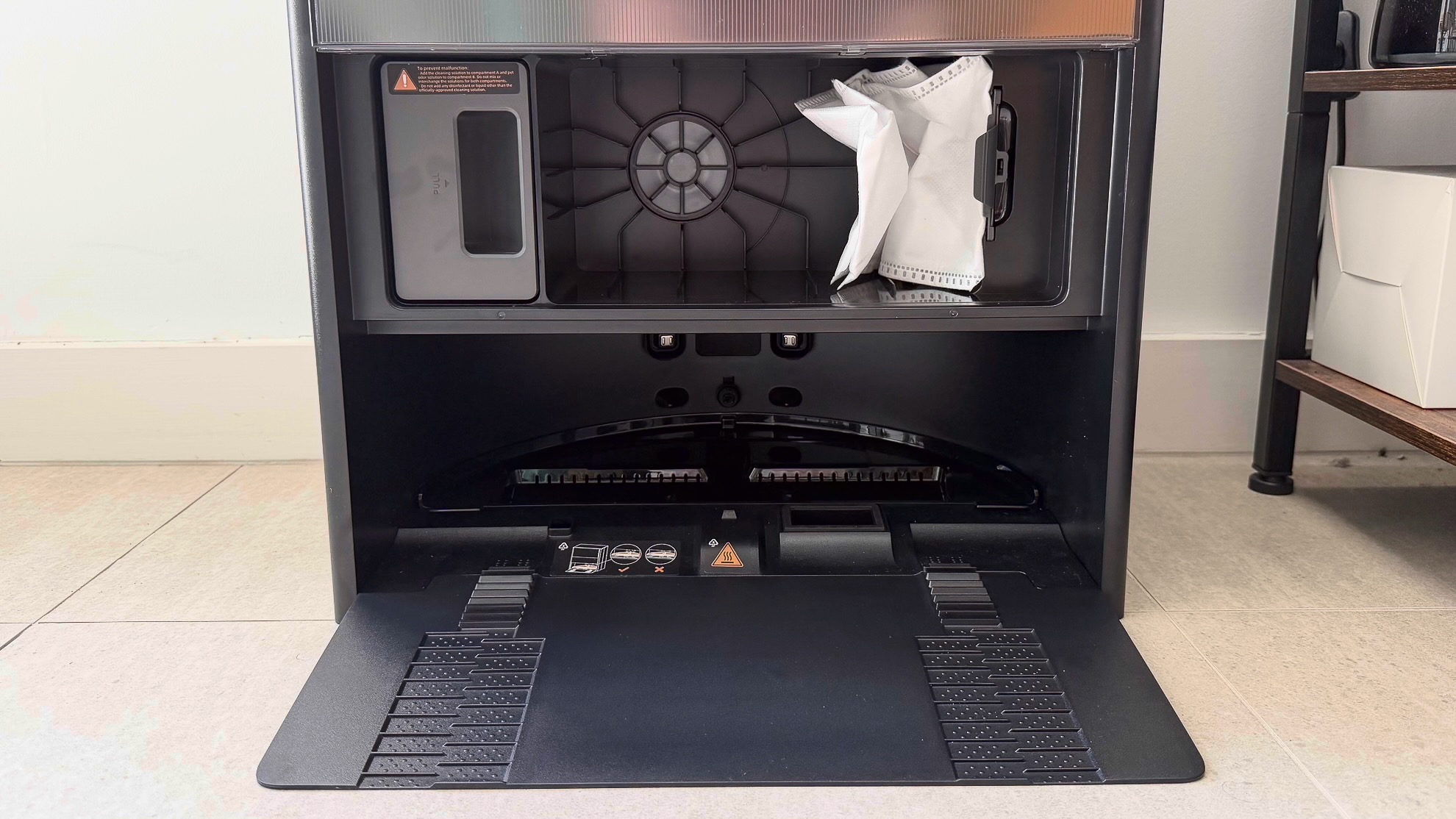 Inside the Dreame Aqua10 Ultra dock showing dust bag and detergent dispenser