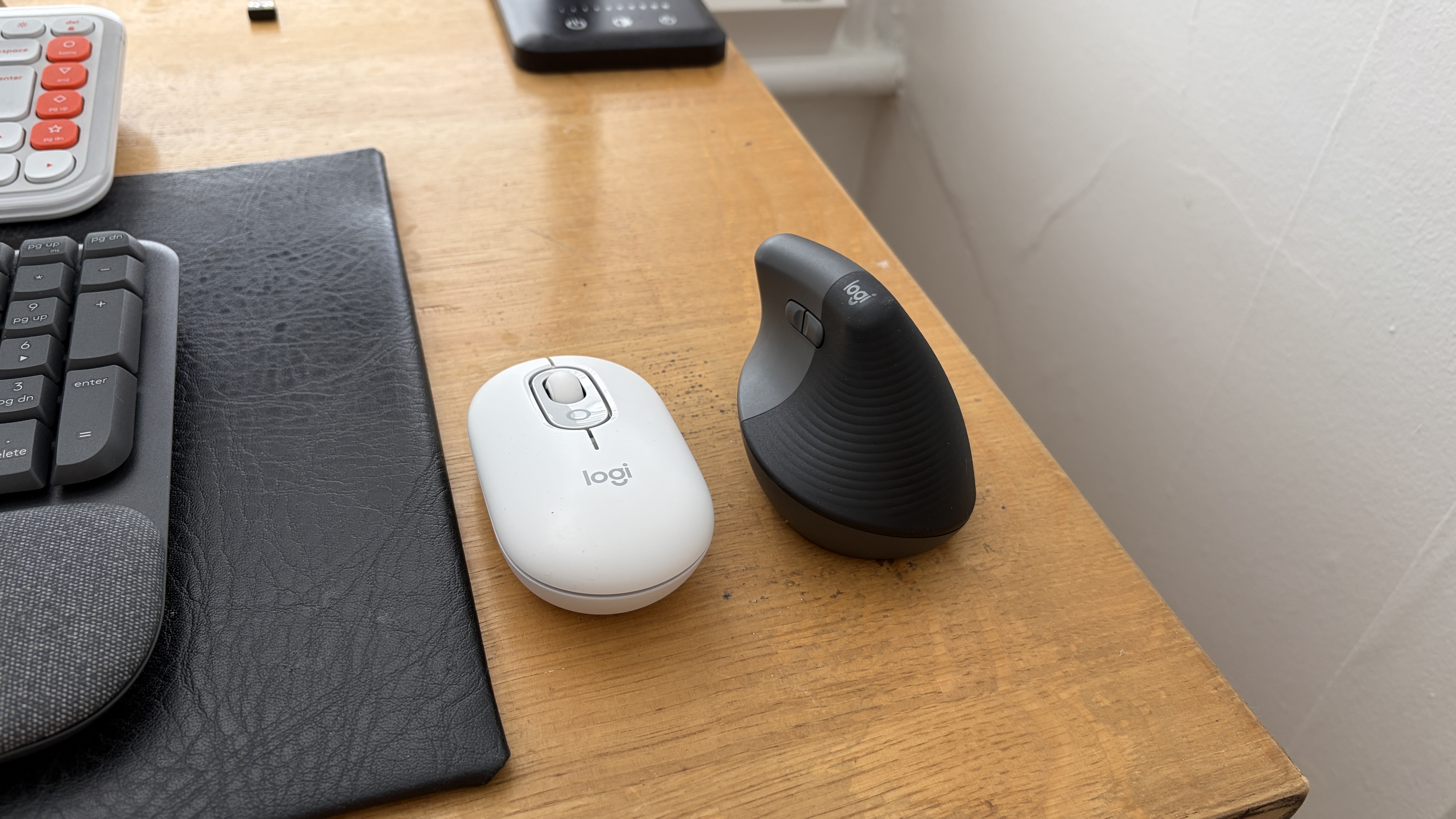 The Logitech Pop next to the Logitech Lift on a wooden table