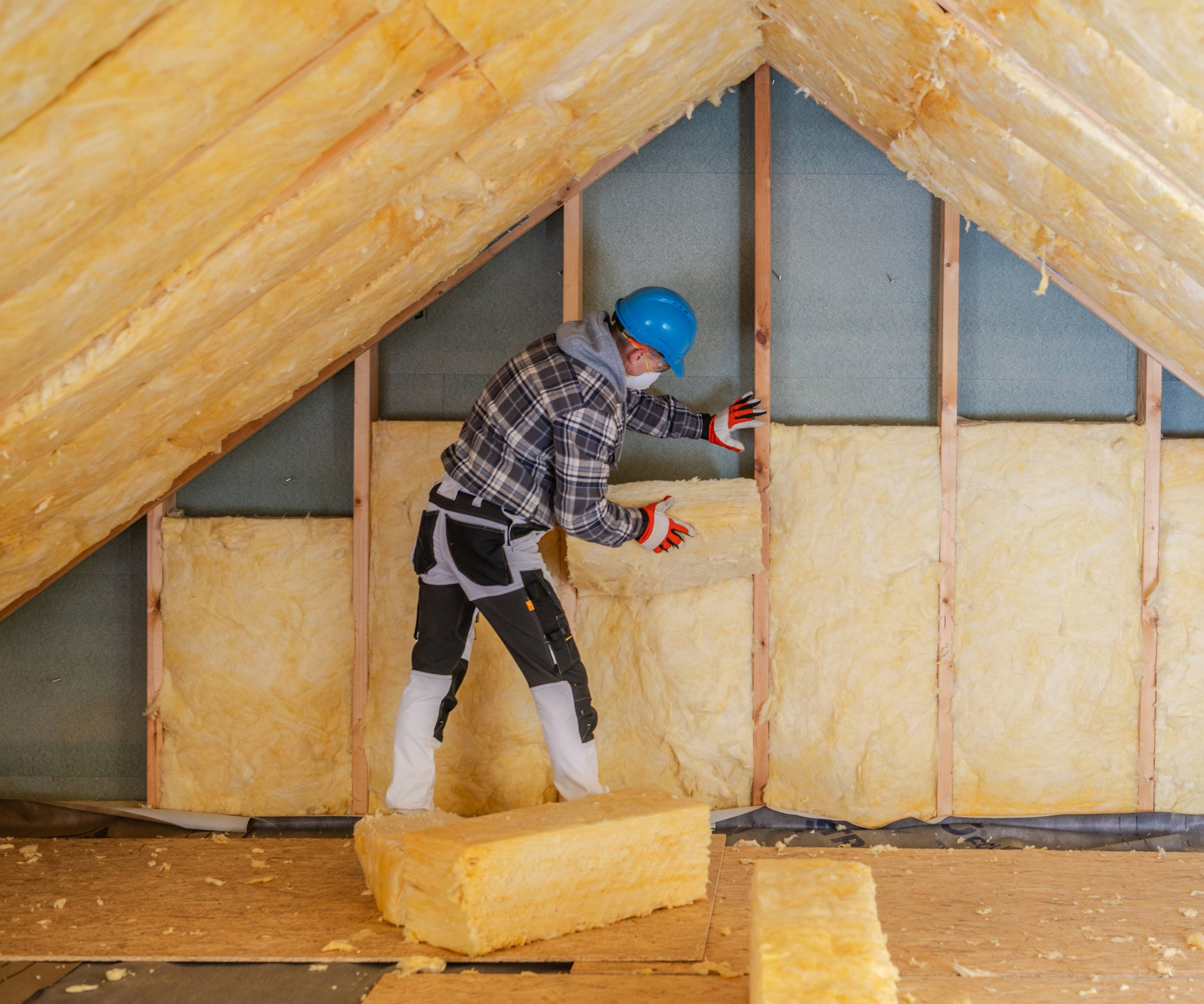 Man fitting insulation in a roof