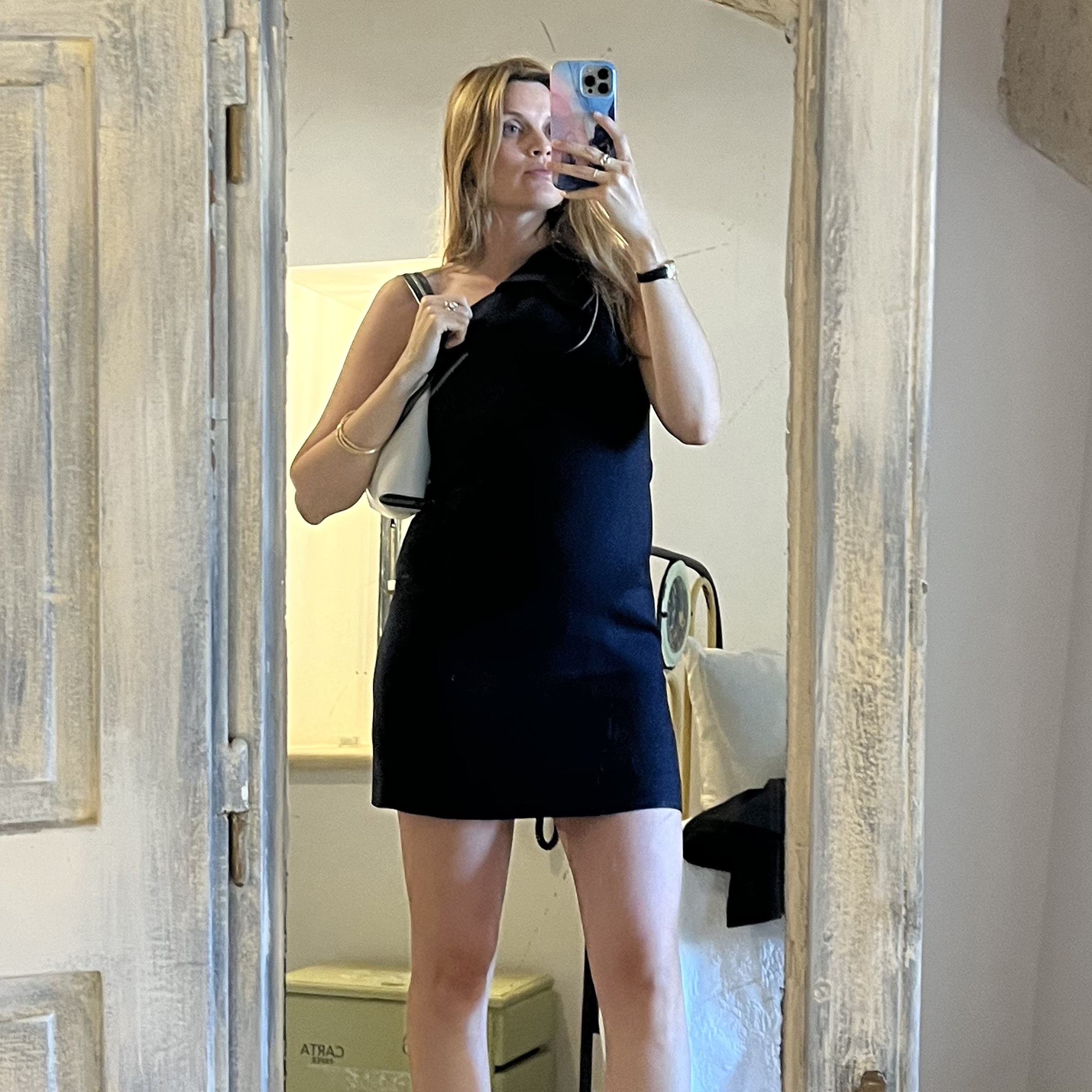 French fashion editor Eugenie Trochu poses for a mirror selfie wearing a black Versace one-shoulder mini dress