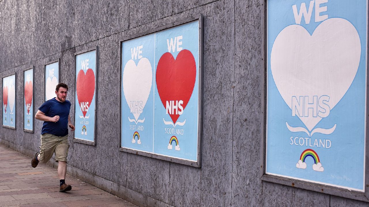 Man running past &amp;#039;We love NHS&amp;#039; signs