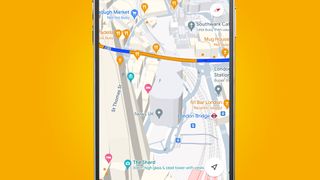 A phone on an orange background showing 3D buildings in the Google Maps app