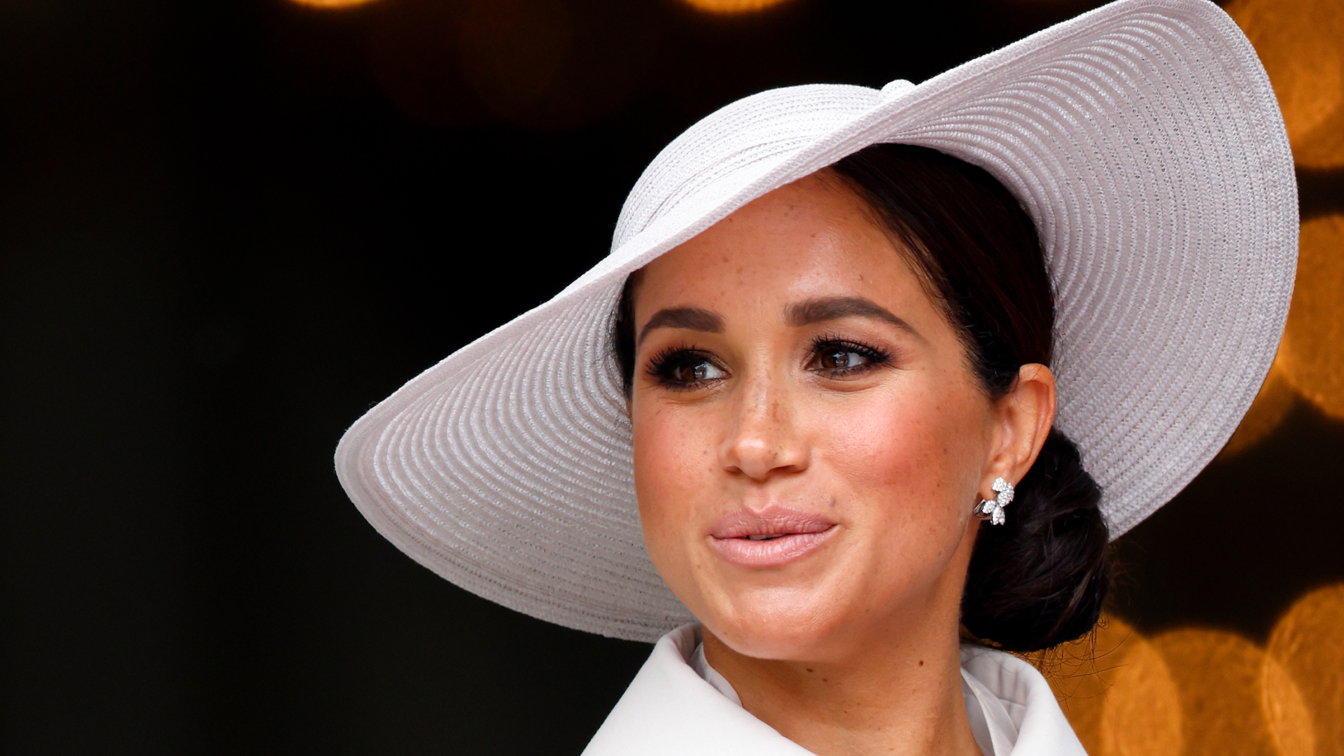 Meghan Markle wearing a white hat and coat