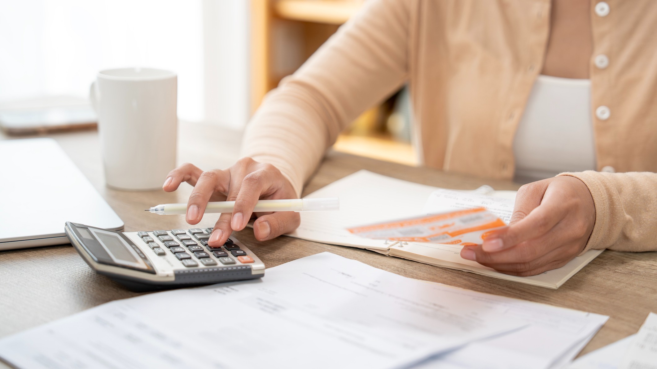 a woman calculating her finances at her kitchen table