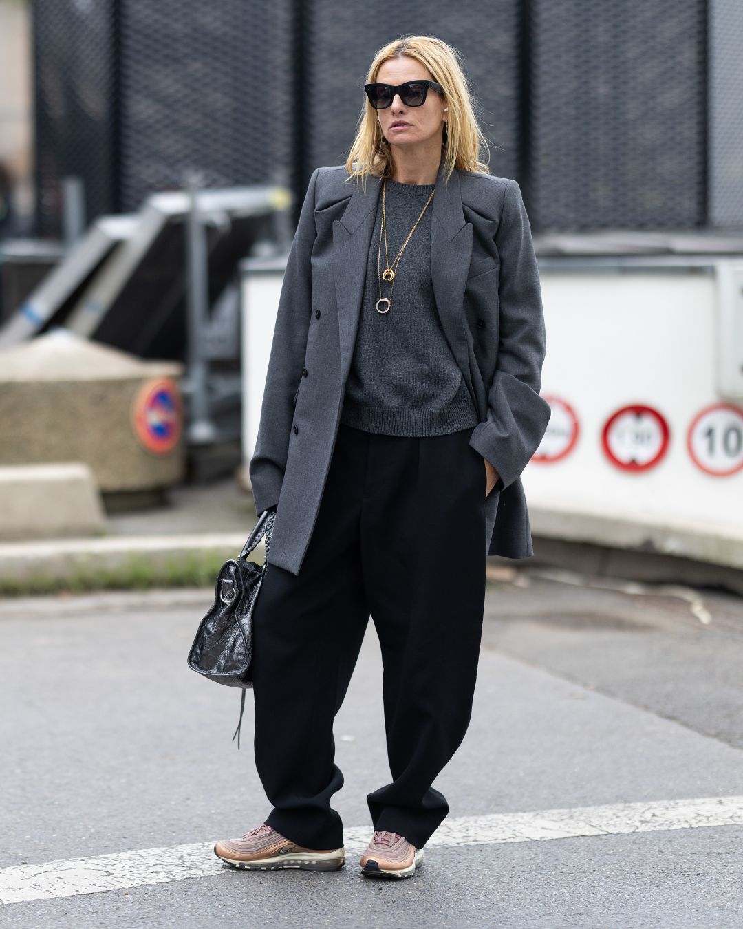 camille charriere wears a grey jumper, jacket and black trousers during fashion week