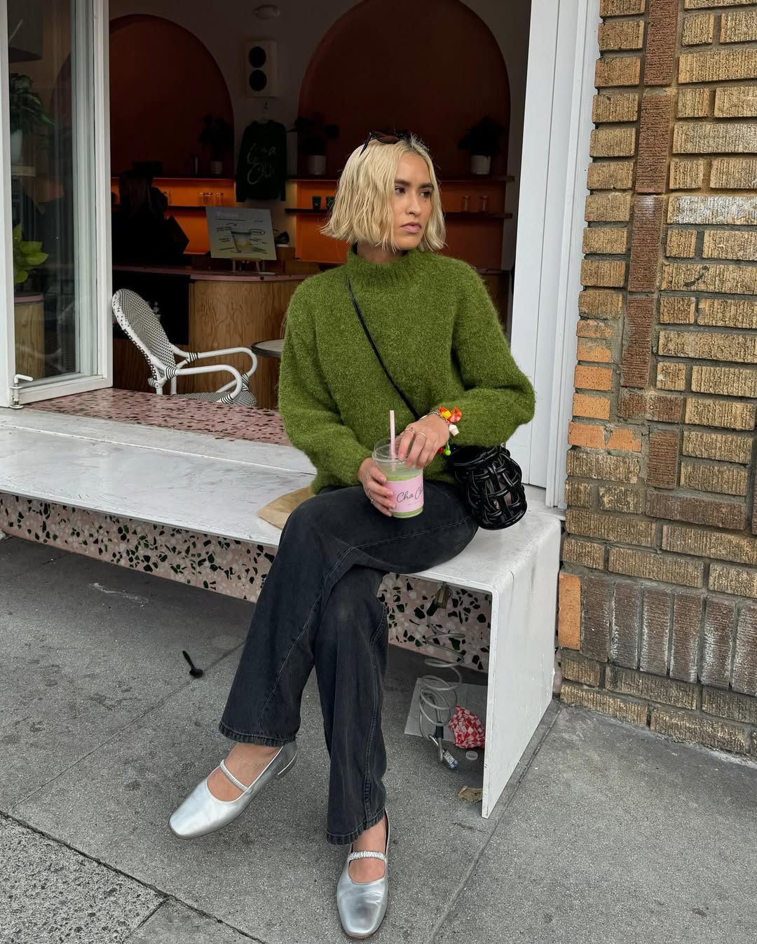 @caitlinmiyako wearing a green jumper with jeans