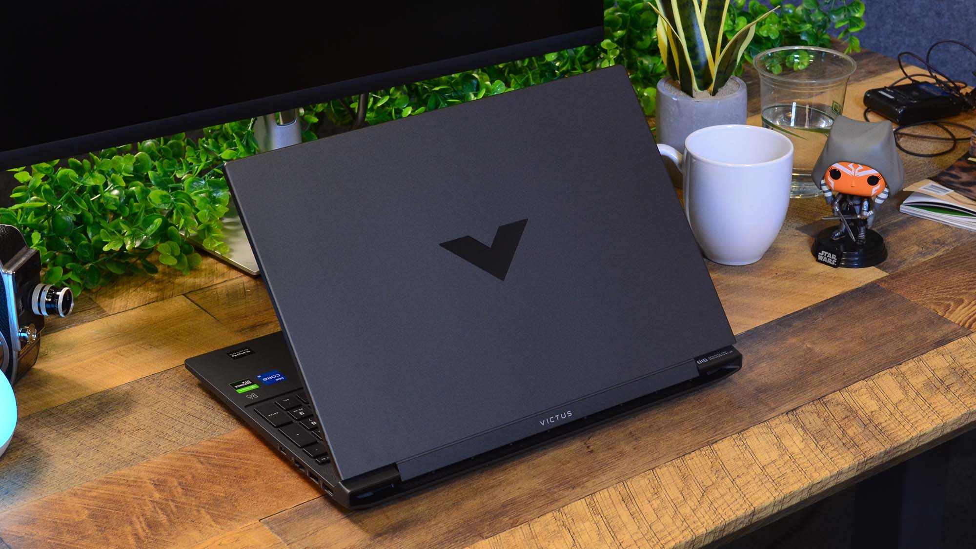 An HP Victus 15 sitting on a desk viewed from rear showing logo on lid