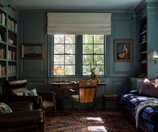 Home library and study painted in a moody color palette