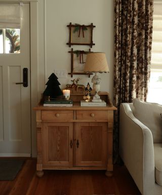 A living room console table decorated with vintage Christmas decor