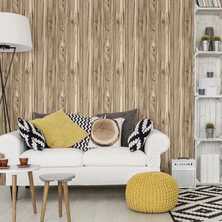 White couch with scatter cushions in front of wooden wall