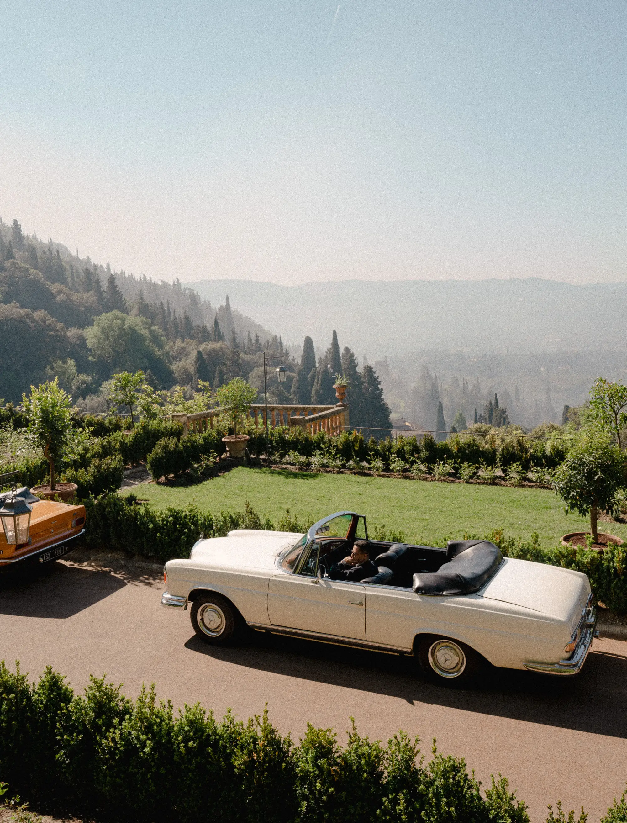 A cream, convertible vintage car outside of Villa San Michele near Florence