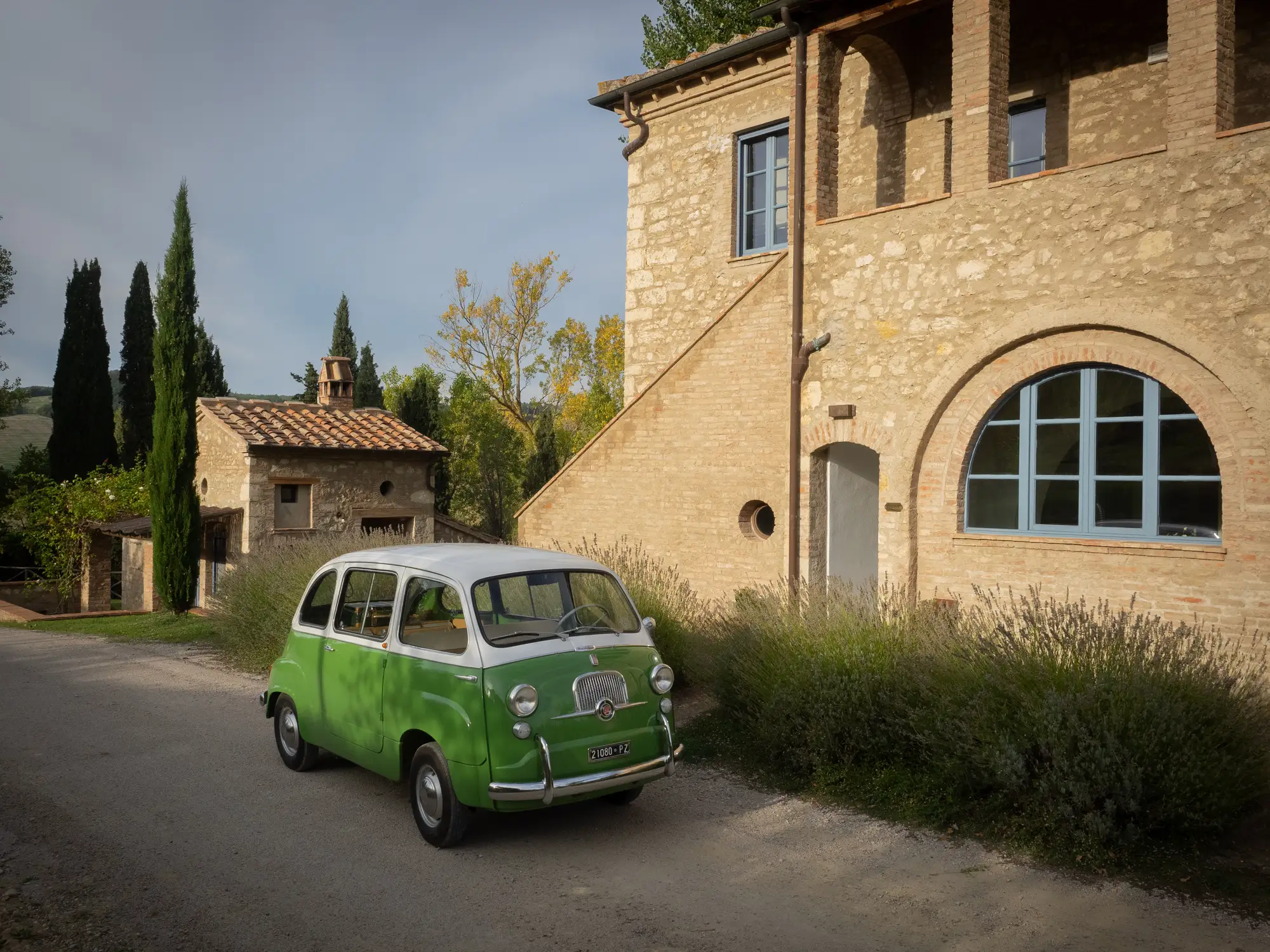 A green vintage car outside of Hotel Borgo Pignano