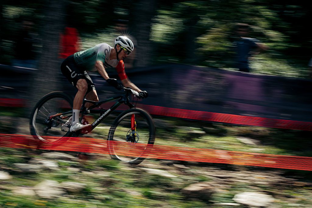Man cycles down a hill blurred