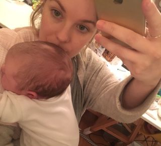 mum holding newborn and taking a selfie