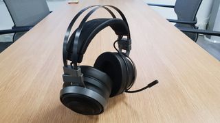 Gaming-headsettet Razer Nari Ultimate i svart på en bordplate i en kontormiljø..