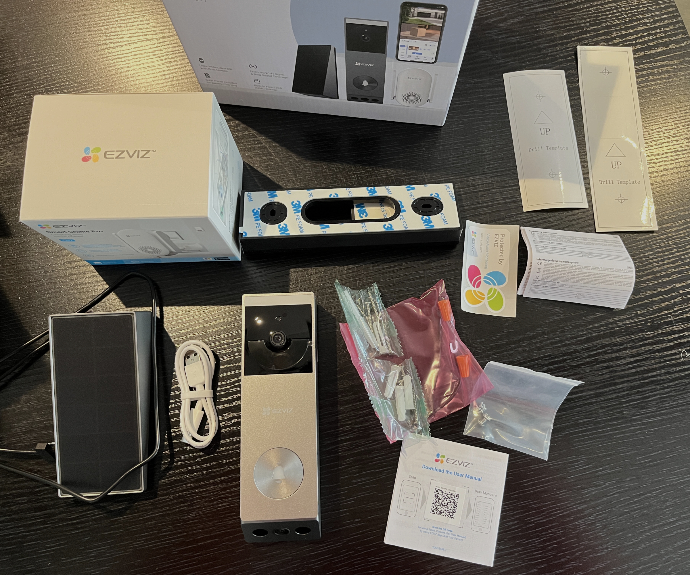 Ezviz video doorbell components unpacked on black dining table