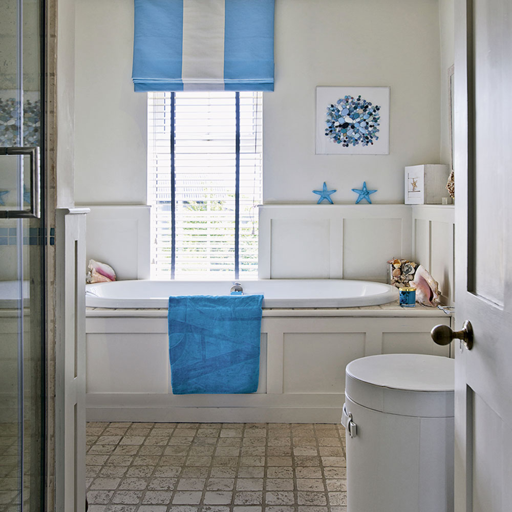 bathroom with white bathtub, tiled floor and wall panelling
