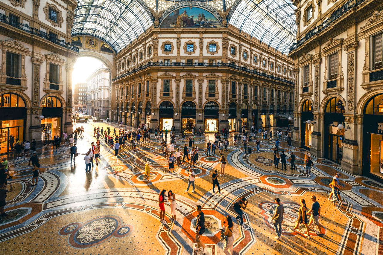 A luxurious arcade filled with people and sunshine.