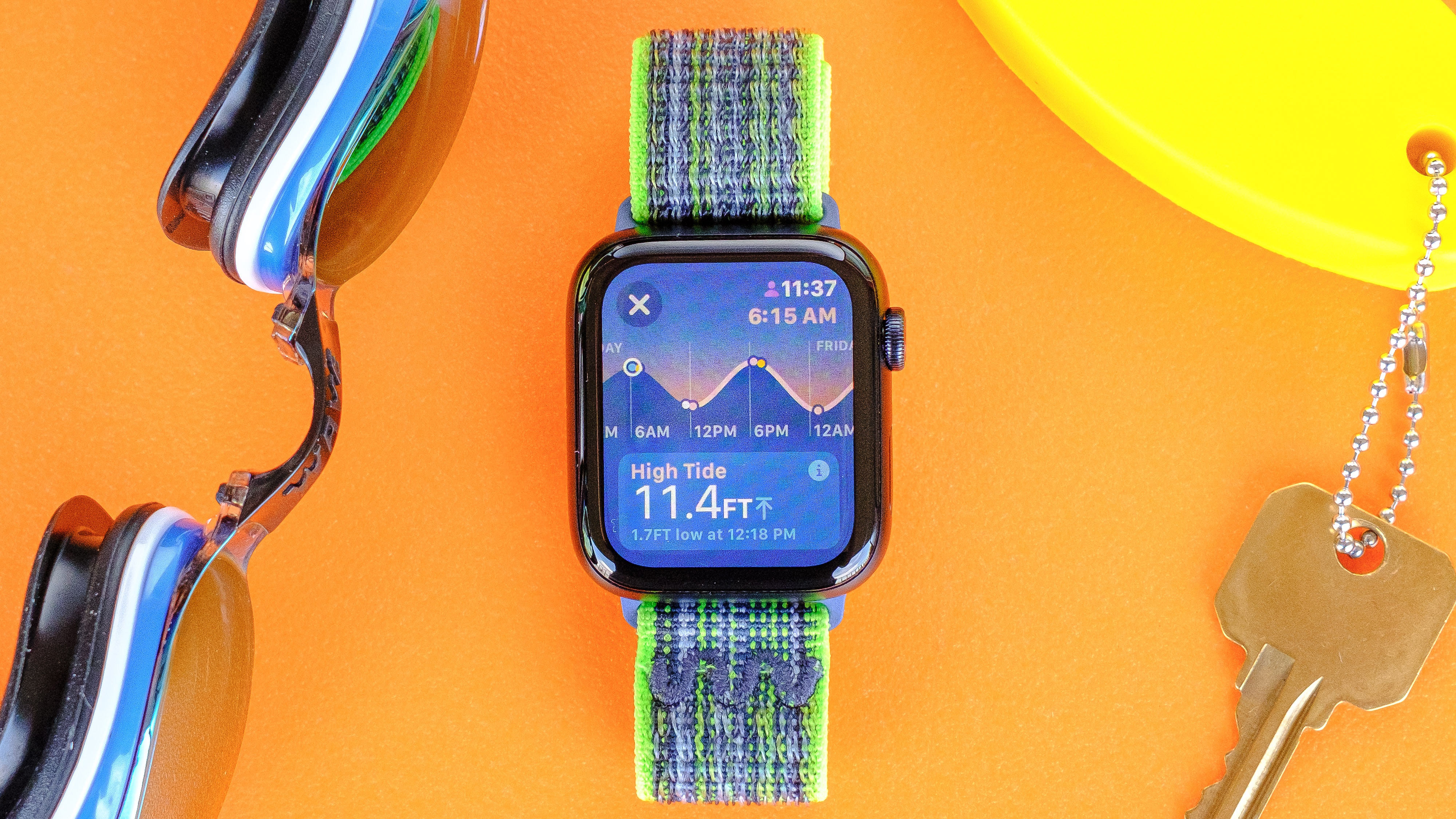 Apple Watch SE 2022 on an orange table with the new Tides app screen displayed