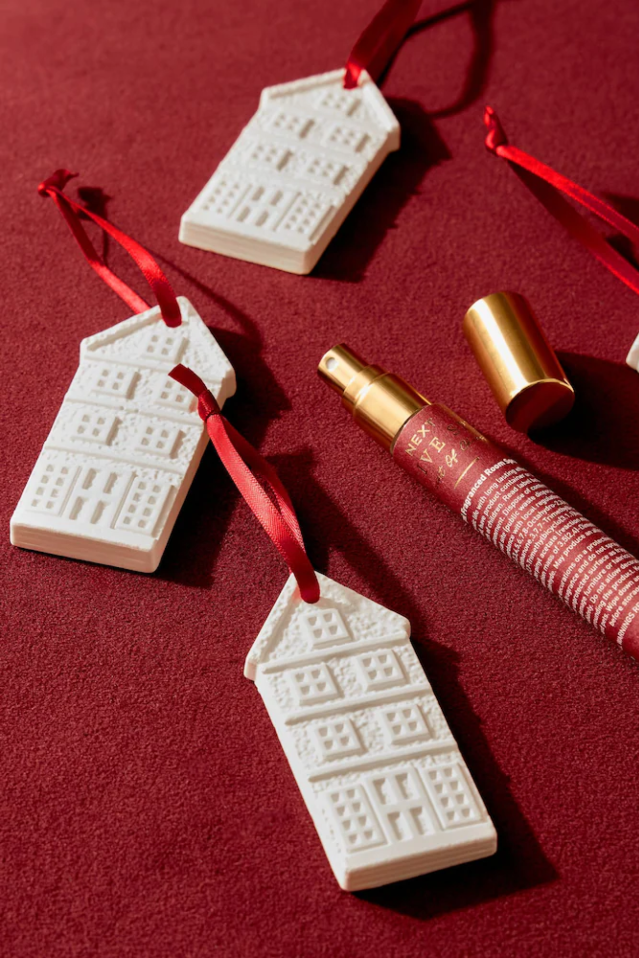 A couple of white building ornaments with a home spray