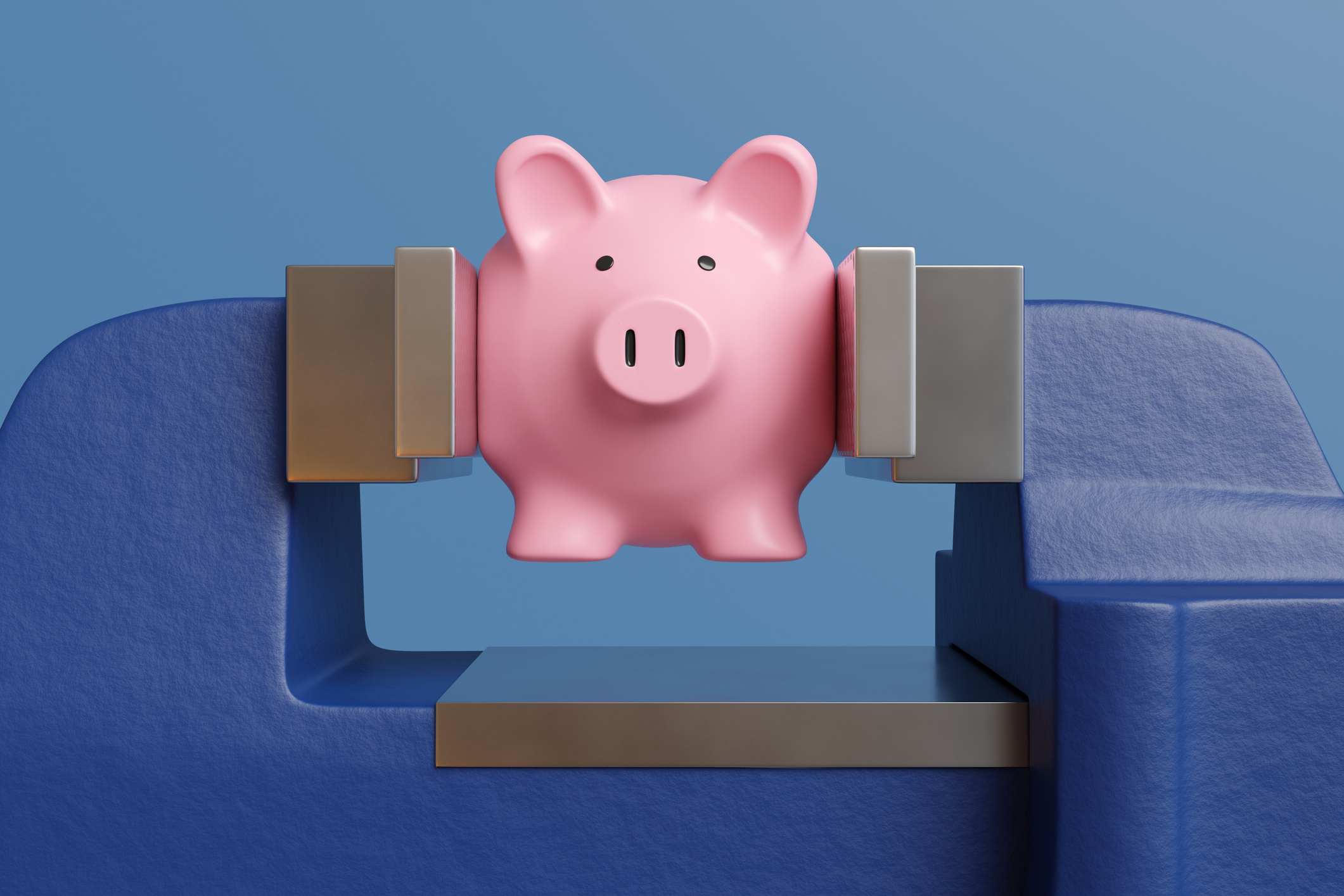 Pink piggy bank being pressed and crushed by a blue vice on blue background to illustrate the concept of financial stress