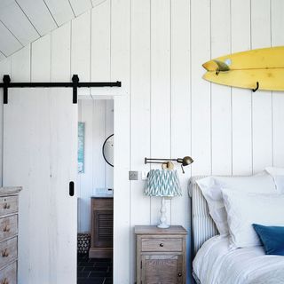 Bedroom with walls and ceiling covered in white panelling