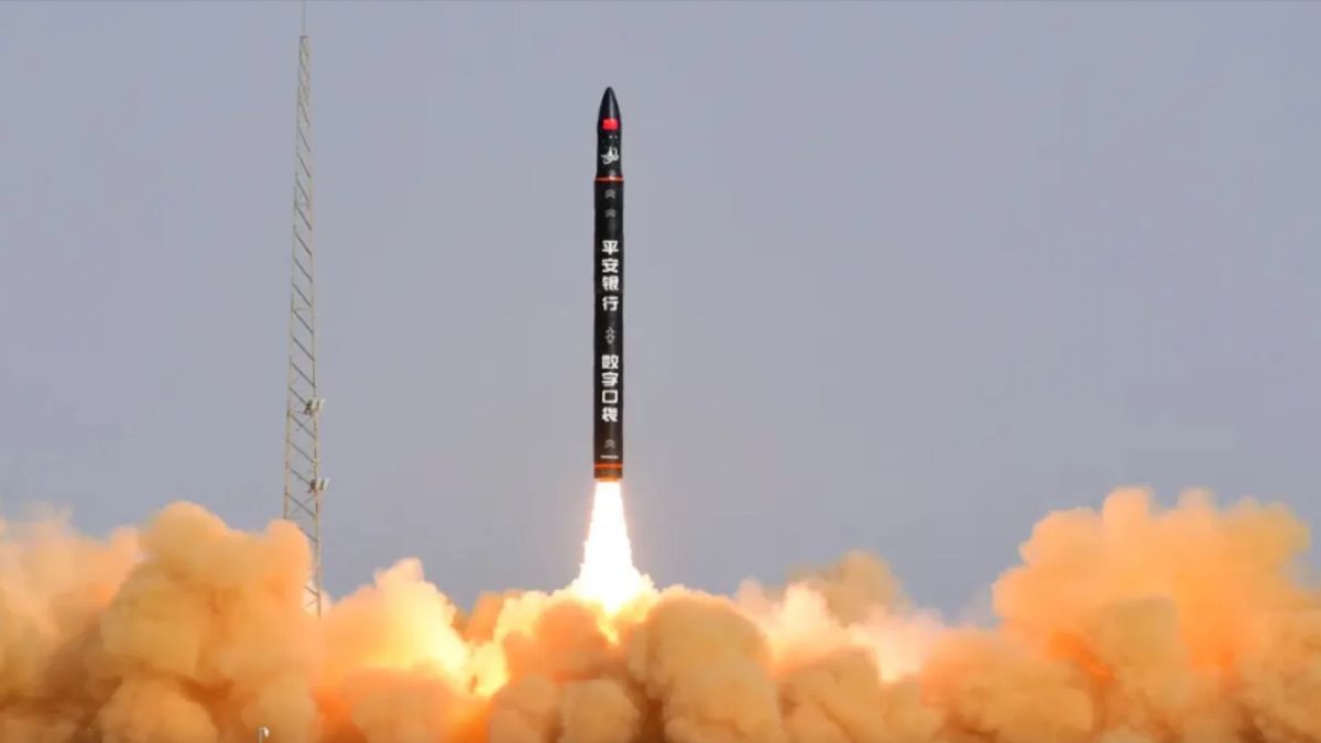 a black rocket lifts off into a blue sky.