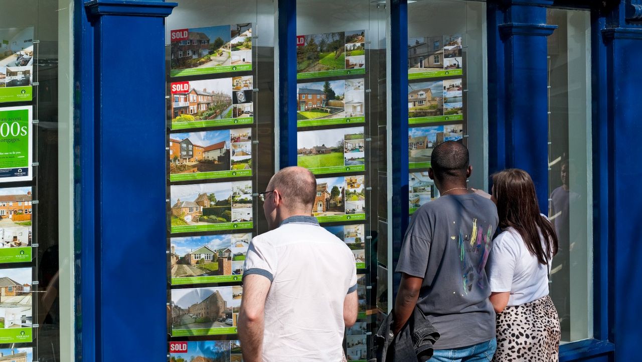 People looking in an estate agents window