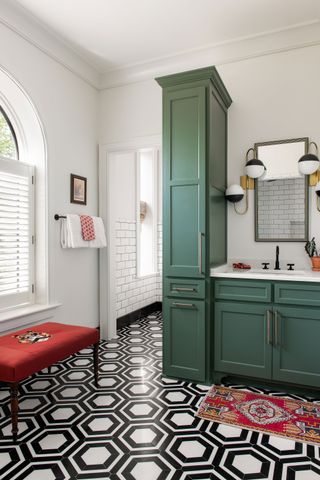 bathroom with dark green cabinets and black and white flooring